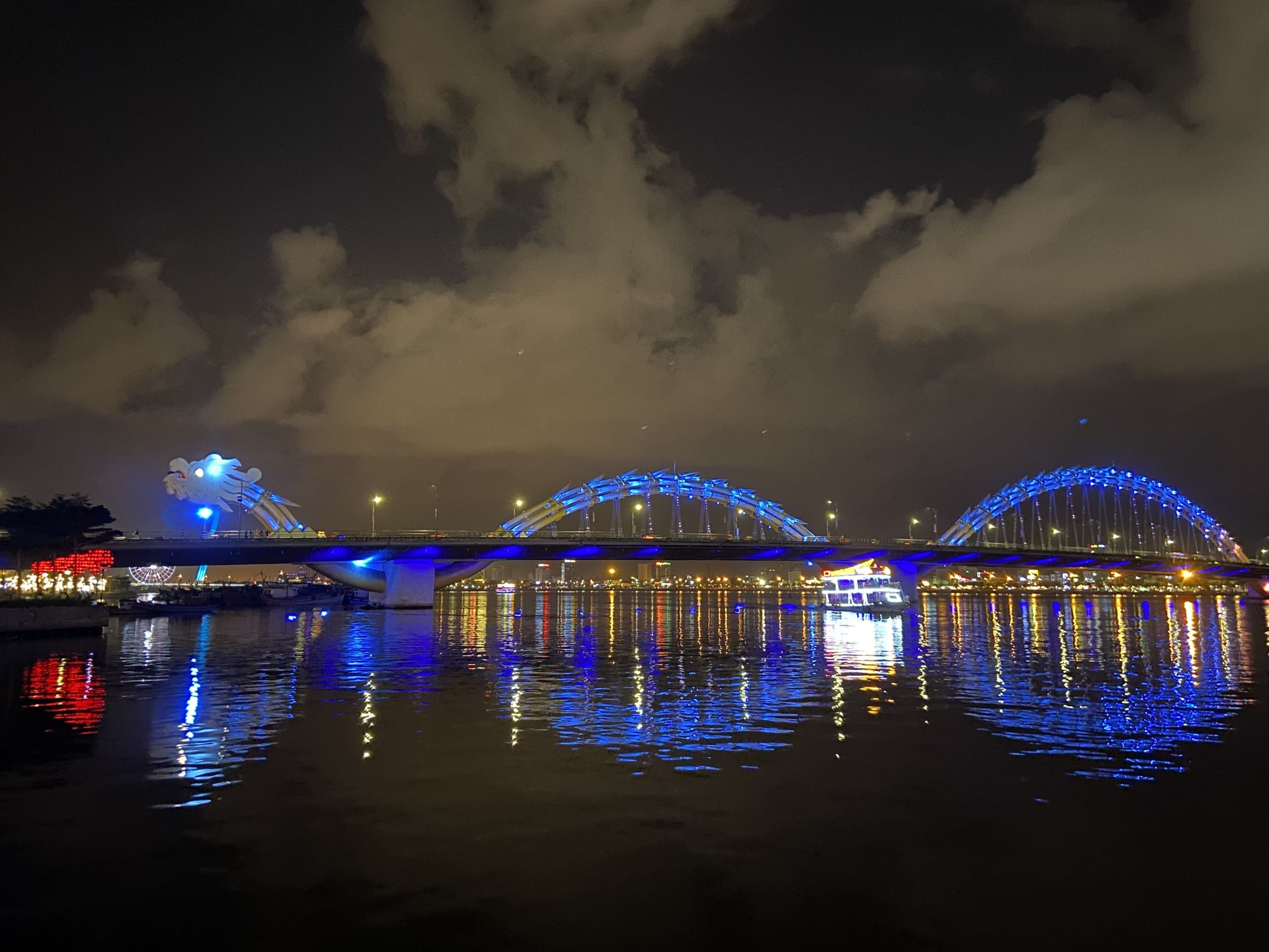 Drachenbrücke Da Nang in der Nacht in blauer Beleuchtung. Samstags und Sonntags ab 20.00 Uhr gehört die Brücke den Besuchern des Drachenspektakels. Dann ist die Drachenbrücke autofrei und hier beginnt um 21.00 Uhr ein riesiges Volksfest. Foto: Kuroczynski via Wiki Commons, CC BY-SA 4.0